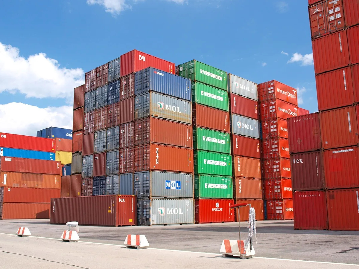 Stacks of ocean containers in a paved storage yard