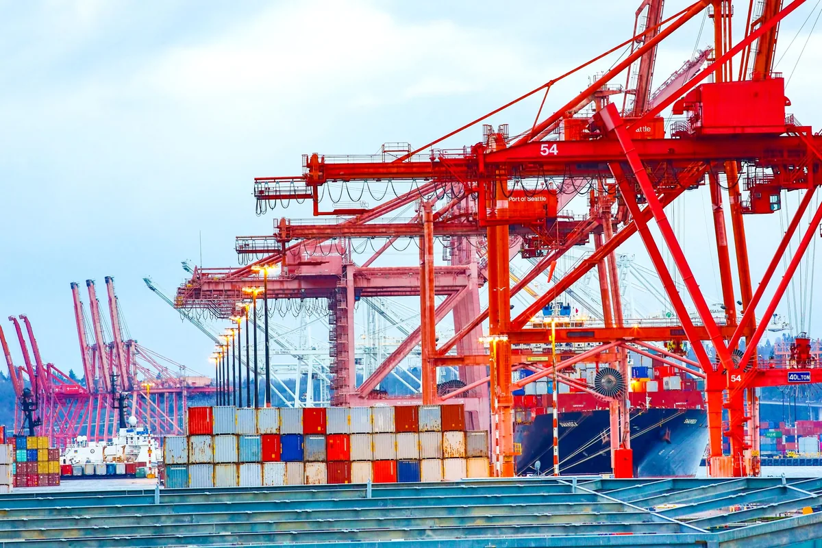 Red container cranes and stacked containers at the Port of Seattle